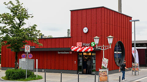Das neue Holzbahnhofgebäude in Haar am Bahnhofsplatz hat eine rote Lärchenholzverkleidung und ein großes Bullauge auf der Ostseite. Hier können Fahrgäste künftig bei einem Kiosk einkaufen und auf die Züge warten.