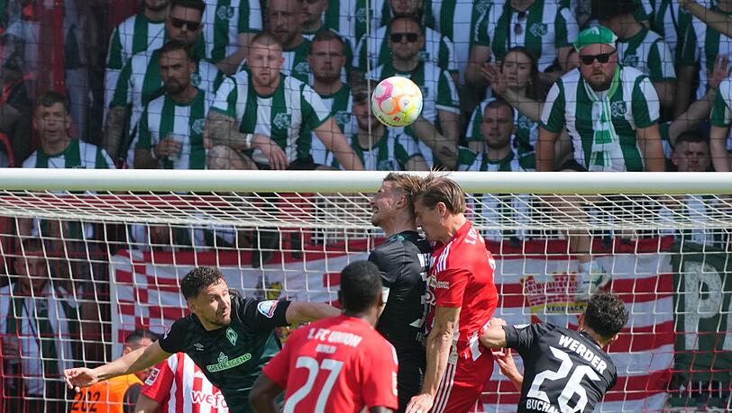 Werder Bremens Marco Friedl (l) und Unions Kevin Behrens im Kopfballduell.
