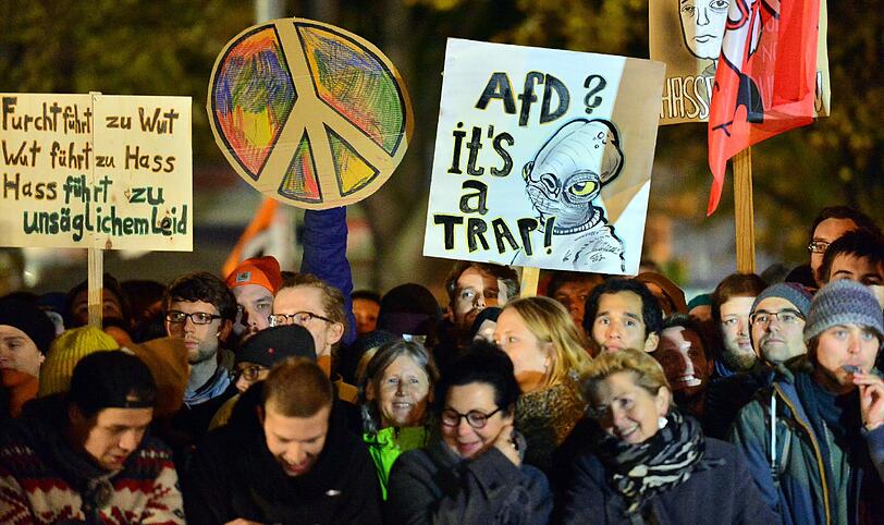 Teilnehmer einer Demonstration protestieren am 21.10.2015 in Erfurt (Thüringen) mit einem Plakat «AfD it's a trap» (AfD ist eine Falle) gegen eine Kundgebung der «Alternative für Deutschland» (AfD).