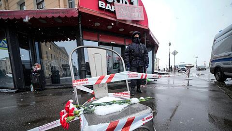 Blumen liegen auf einem Stuhl nahe des Explosionsortes, dem Café "Street Bar" in St. Petersburg.