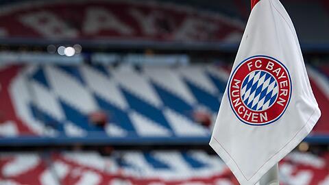 Eine Eckfahne mit dem Logo vom FC Bayern München hängt im Stadion.