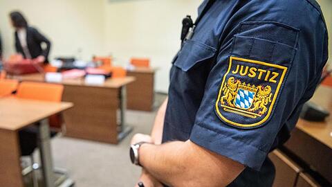 Ein Justizbeamter zu Beginn des Prozesses im Sitzungssaal vom Landgericht München II.