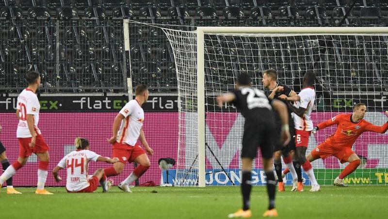 Mönchengladbachs Hannes Wolf (l) erzielt das 1:0 gegen Leipzigs Torwart Peter Gulacsi.