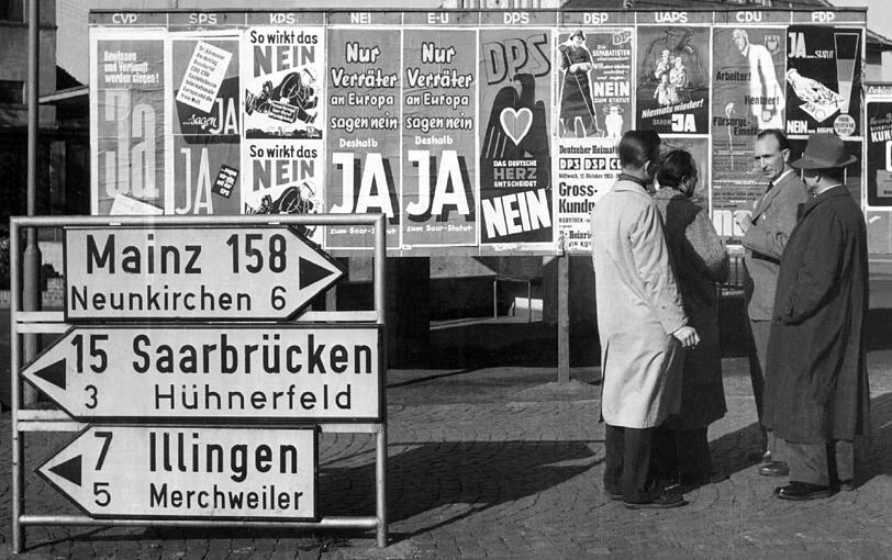 Rege Diskussionen führen Passanten am 20. Oktober 1955 in Beckingen (Saarland) vor einer Anschlagtafel, auf der alle zugelassenen Parteien ihr Für und Wider das zwischen Paris und Bonn vereinbarte "Europäische Saarstatut" propagieren (Archivfoto). Bei der Volksabstimmung am 23.10.1955 entschied sich die Bevölkerung des Saarlandes gegen das Saarstatut und damit für die Rückkehr des Grenzlandes zur Bundesrepublik.
