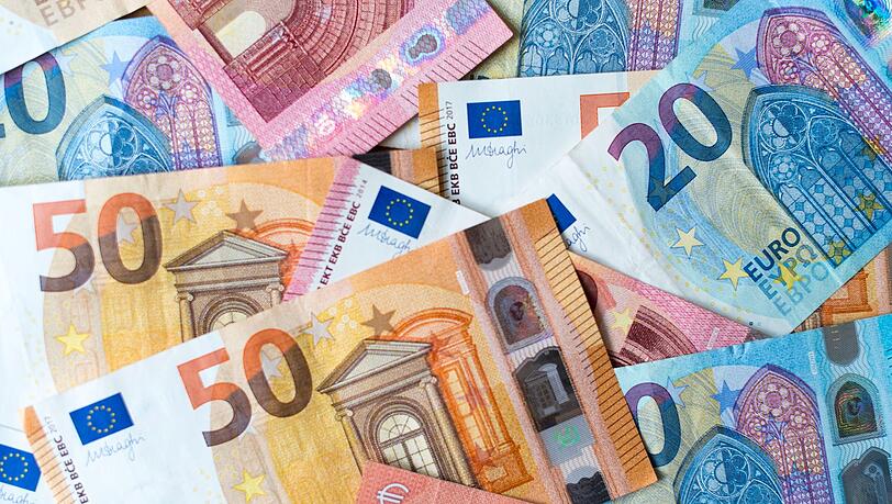 Zahlreiche Banknoten zu 10, 20 und 50 Euro liegen auf einem Tisch.