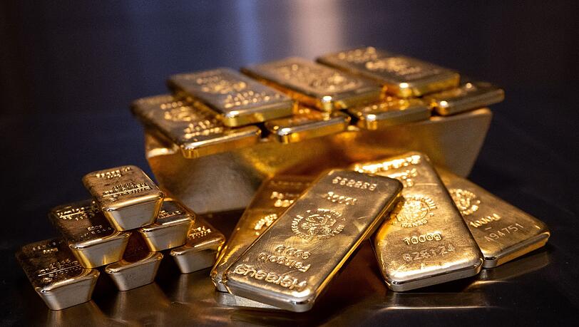 Goldbarren in unterschiedlicher Größe liegen bei einem Edelmetallhändler in einem Tresor auf einem Tisch.