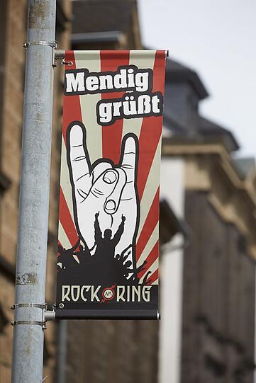Auch die Gemeinde begrüßte doe Festivalfahrer: Ein Banner mit der Aufschrift «Mendig grüßt» ist am Rande des Rockfestivals "Rock am Ring" an einem Laternenmast befestigt.