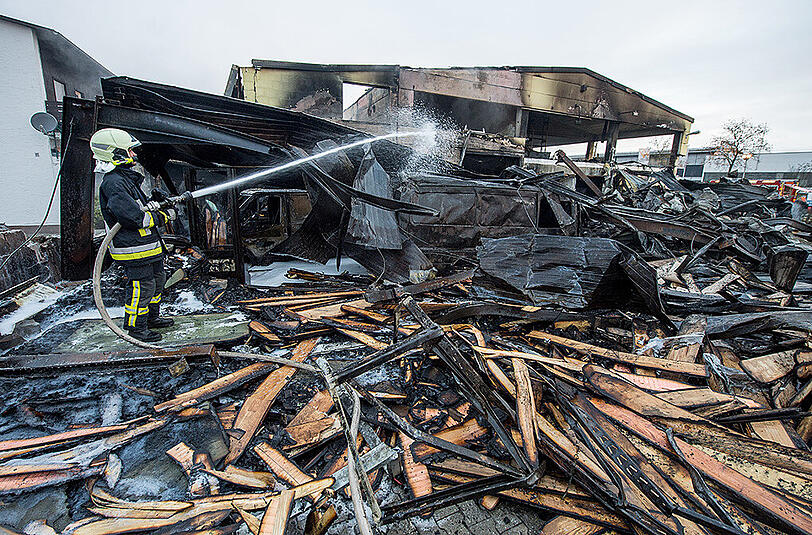 Bilder vom Morgen nach dem Brand: Einsatzkräfte der Feuerwehr an den Überresten der Lagerhalle.