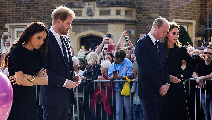 Zwei Tage nach dem Tod von Königin Elizabeth II.: Meghan, Harry, William und Kate betrachten die abgelegten Blumen, Bilder und Briefe vor Schloss Windsor