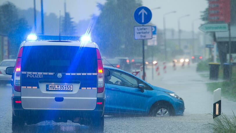 Bei starkem Regen steht ein Auto auf der überschwemmten B111 in Zinnowitz auf der Insel Usedom (Mecklenburg-Vorpommern). Bei starkem Regen steht ein Auto auf der überschwemmten B111 in Zinnowitz auf der Insel Usedom (Mecklenburg-Vorpommern).