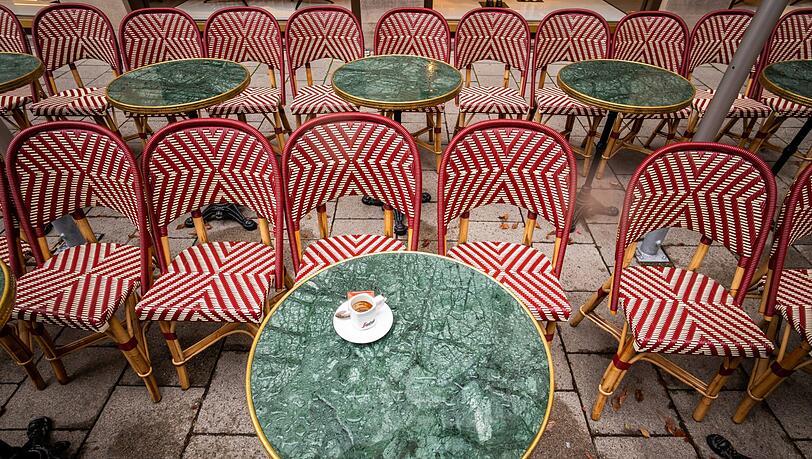 Eine Espresso-Tasse steht auf dem regennassen Tisch eines Cafés in der Innenstadt. Eine Espresso-Tasse steht auf dem regennassen Tisch eines Cafés in der Innenstadt.