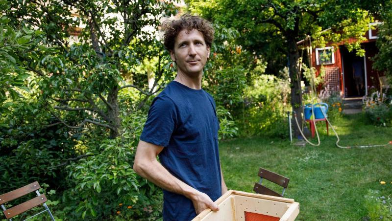 Der Imker Jonas Hörning hält einen Bienenkasten, um einen herrenlosen Bienenschwarm in einer Kleingartenanlage einzufangen. Der Imker Jonas Hörning hält einen Bienenkasten, um einen herrenlosen Bienenschwarm in einer Kleingartenanlage einzufangen.