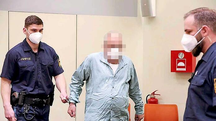 Ein Angeklagter wird in den Gerichtssaal geführt.