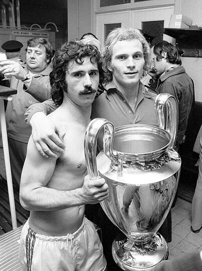 "WAS SOLL ICH SAGEN? DAS WAR WELTKLASSE": 17. Mai 1974 Bayern &ndash; Atletico Madrid 4:0; Landesmeister-Finale: Bayerns erster Triumph im größten Cup-Wettbewerb stand unter kuriosen Vorzeichen. Man spielte freitags, denn zwei Tage zuvor hatte es keinen Sieger gegeben: Katsche Schwarzenbeck glich in letzter Minute aus zum 1:1, Elferschießen war noch nicht erfunden. Also Wiederholung vor halbleeren Rängen, die meisten Fans hatten nur einen Kurz-Trip nach Brüssel gebucht. 30.000 Augenzeugen sahen zu. 4:0 hieß es nach 90 grandiosen Minuten, den Torsegen spendeten Uli Hoeneß und Gerd Müller zu gleichen Teilen. Trainer Udo Lattek: &bdquo;Was soll ich sagen? Das war Weltklasse!&ldquo; 80.000 empfingen die Champions.