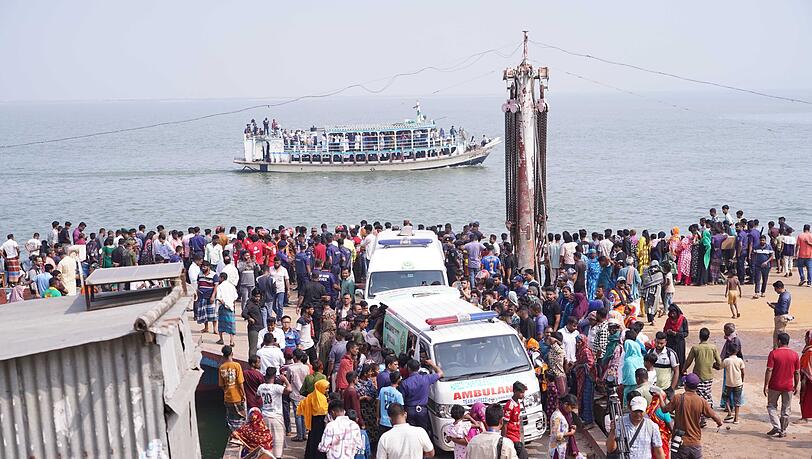 Rettungskr&auml;fte und zahlreiche Menschen versammeln sich an einer Unfallstelle, nachdem ein Bus in den Fluss Padma st&uuml;rzte.