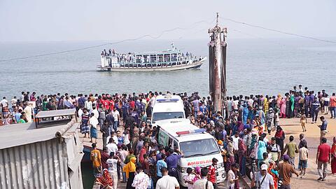 Rettungskr&auml;fte und zahlreiche Menschen versammeln sich an einer Unfallstelle, nachdem ein Bus in den Fluss Padma st&uuml;rzte.