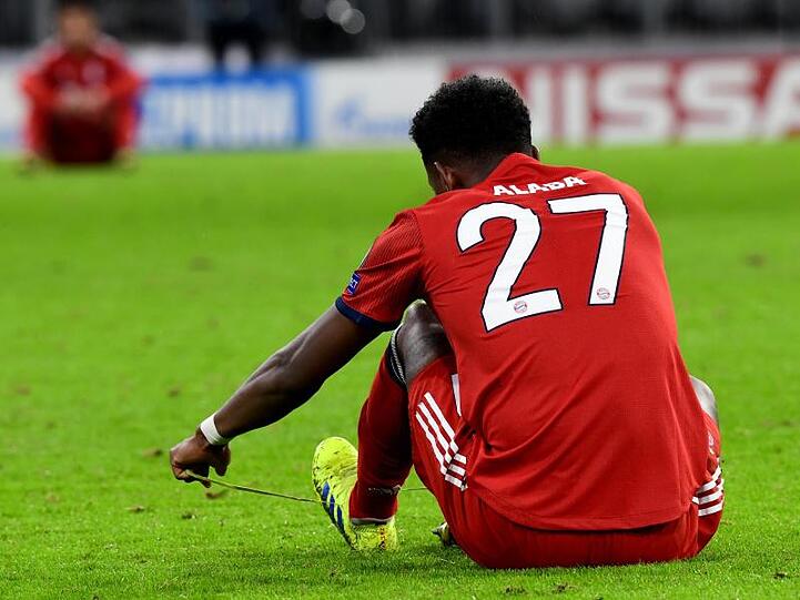 Münchens David Alaba sitzt nach der 1:3-Niederlage auf dem Rasen und schnürt sich die Schuhe. Foto: Peter Kneffel/Archiv