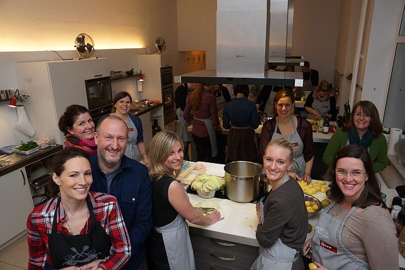 Gemeinsam Kochen macht Spaß: Erwin und Valerie Lanzensberger (links) im Kochraum mit Gästen.