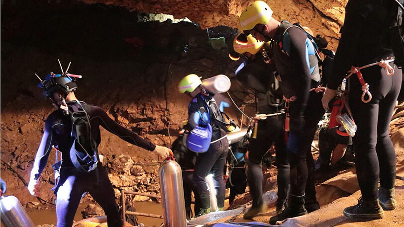 Auf ihnen ruht die Hoffnung: Mitglieder des thailändischen Rettungsteams gehen in die Höhle hinein.