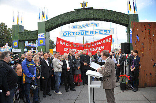 Beim Gedenken an das Oktoberfestattentat wird ein Banner mit der Forderung "Für die Wiederaufnahme des Ermittlungsverfahrens" hochgehalten.