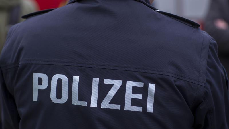 "Polizei" steht auf der Uniform eines Polizisten.