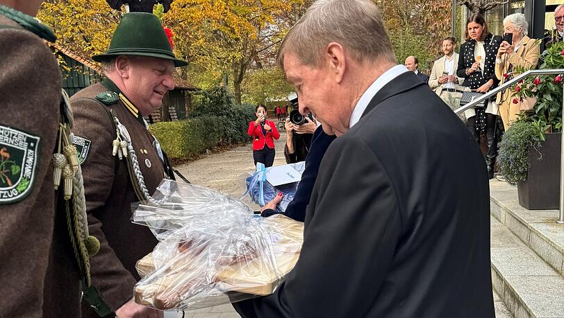 Ein Brotzeitbrettl zum 80sten: Otto Wieshau vor der Gaststätte Hirschau im Englischen Garten inspiziert das Präsent von einem Gebirgsschützen zu seinem runden Geburtstag.