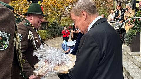 Ein Brotzeitbrettl zum 80sten: Otto Wieshau vor der Gaststätte Hirschau im Englischen Garten inspiziert das Präsent von einem Gebirgsschützen zu seinem runden Geburtstag.