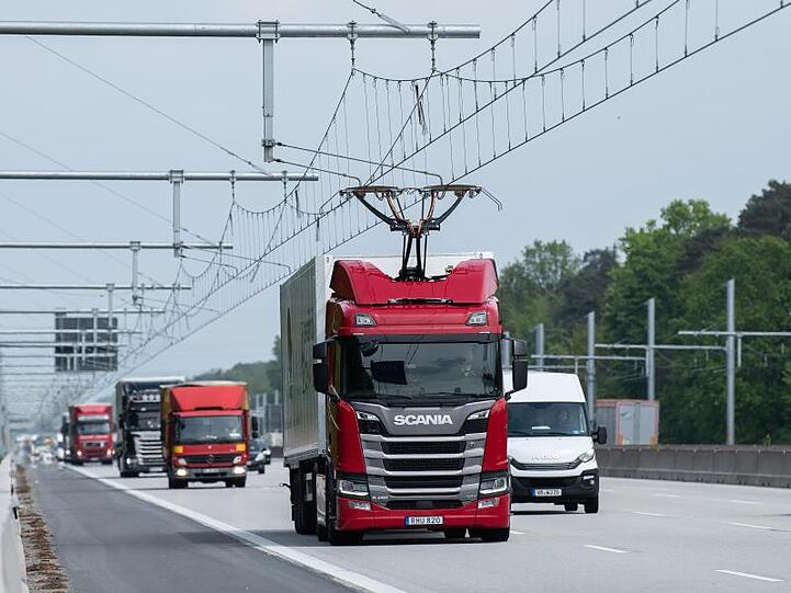 Eine Scania R450 Hybrid Zugmaschine (M) fährt während der Inbetriebnahme der ersten deutschen Teststrecke für E-Lastwagen mit Oberleitung auf der Autobahn 5.