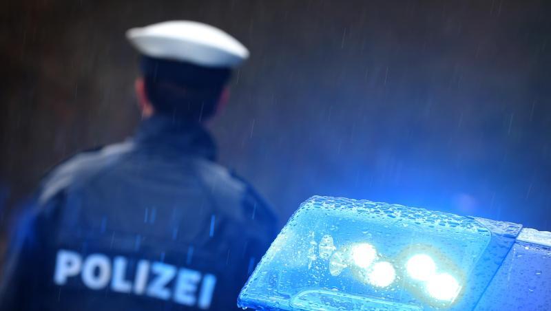 Ein Polizist steht im Regen vor einem Streifenwagen dessen Blaulicht aktiviert ist. Foto: Karl-Josef Hildenbrand/dpa/Archivbild Ein Polizist steht im Regen vor einem Streifenwagen dessen Blaulicht aktiviert ist. Foto: Karl-Josef Hildenbrand/dpa/Archivbild
