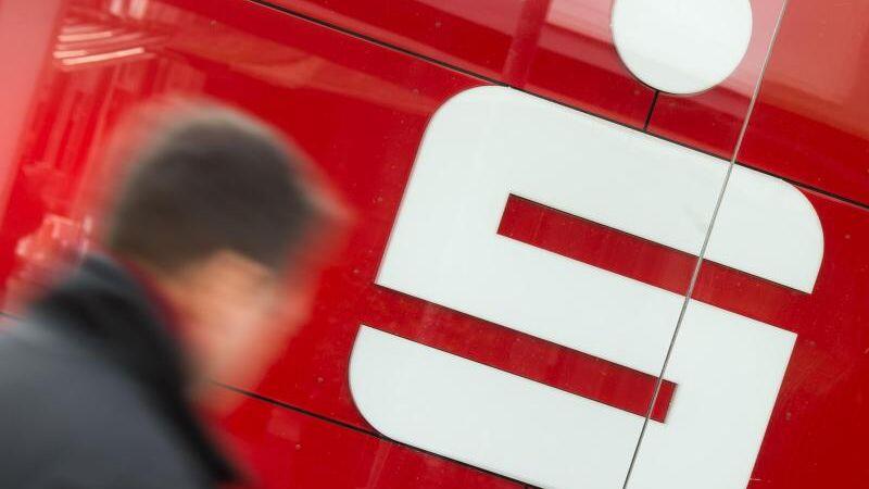 Ein Mann geht an einer Filiale der Sparkasse vorbei. Foto: Julian Stratenschulte/Archiv