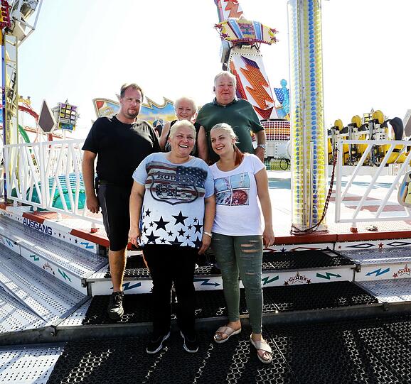 Schausteller-Familie Kaiser vor dem elterlichen Skater-Karussell: Sylvia und Siegfried Kaiser mit Sohn Sascha. Vorne stehen Jasmin und Joanna Kaiser.