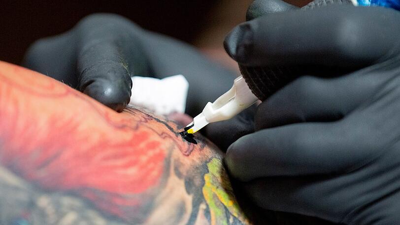 Mit einer Tätowiernadel sticht ein Tattoo-Artist ein Tattoo. (Symbolbild)