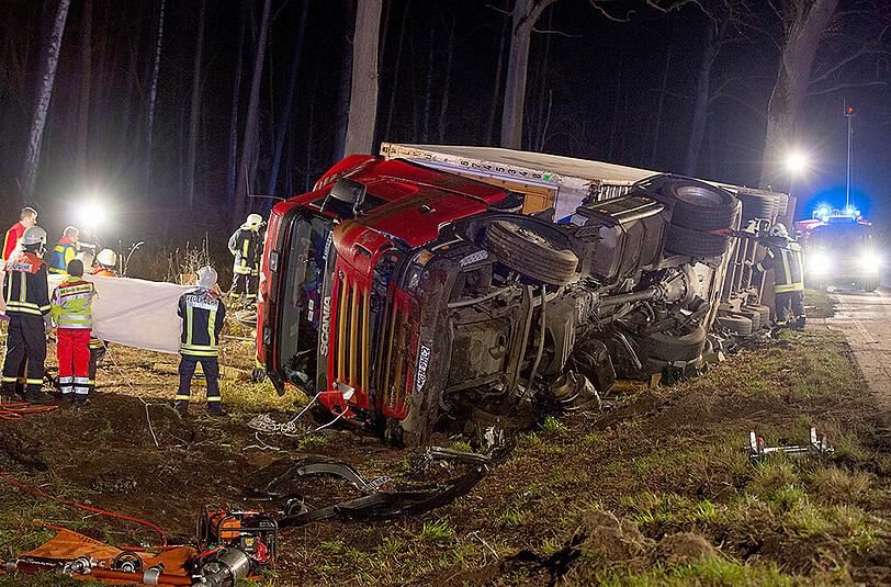 Schrecklicher Unfall nahe Berlin: Aus bislang ungeklärter Ursache kippte ein Lkw auf ein voll besetztes Auto.