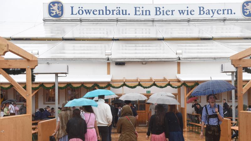Gäste mit Regenschirmen gehen in München (Bayern) auf dem Oktoberfest in das Löwenbräuzelt. Foto: Felix Hörhager/Archiv Gäste mit Regenschirmen gehen in München (Bayern) auf dem Oktoberfest in das Löwenbräuzelt. Foto: Felix Hörhager/Archiv