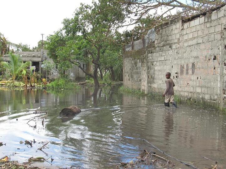 Ein Junge watet durch das Hochwasser zu seinem Haus in der Stadt Beira.