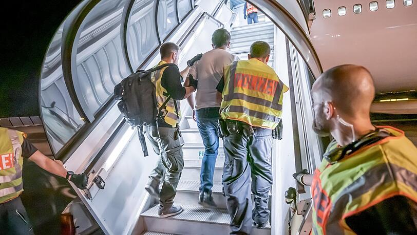 Polizeibeamte begleiten einen Afghanen in ein Charterflugzeug. Polizeibeamte begleiten einen Afghanen in ein Charterflugzeug.