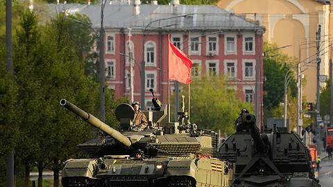 Ein russischer Panzer und eine Panzerhaubitze rollen auf einer Straße in Richtung Roter Platz, um an einer Probe für die Militärparade zum Tag des Sieges  teilzunehmen.