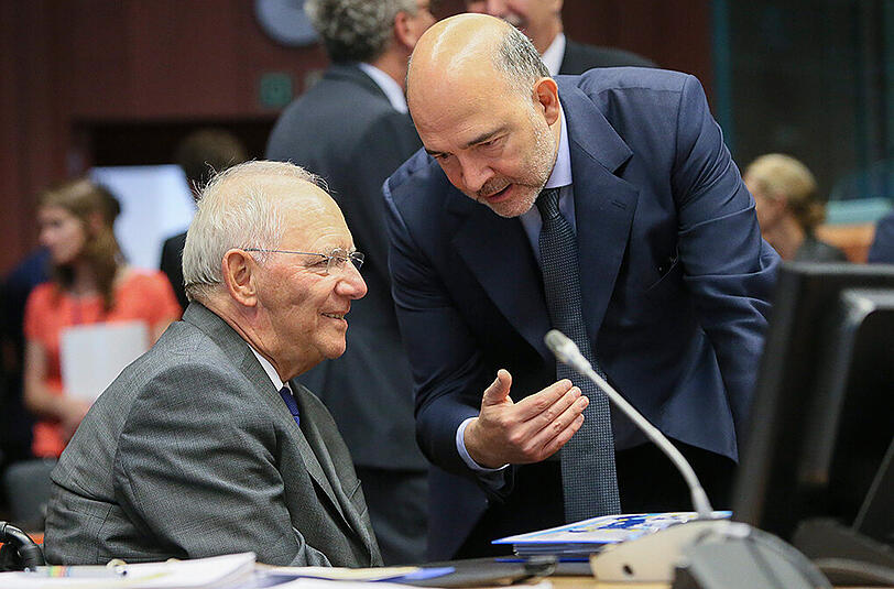 Bundesfinanzminister Wolfgang Schäuble spricht vor dem Finanzministertreffen in Brüssel mit dem EU-Finanzkommissar Pierre Moscovici. Foto: Olivier Hoslet