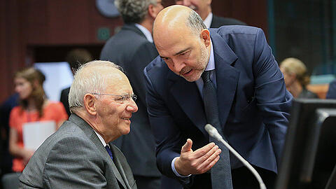 Bundesfinanzminister Wolfgang Schäuble spricht vor dem Finanzministertreffen in Brüssel mit dem EU-Finanzkommissar Pierre Moscovici. Foto: Olivier Hoslet