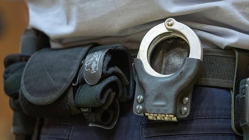 Handschellen stecken in der Gürtelhalterung eines Justizbeamten.