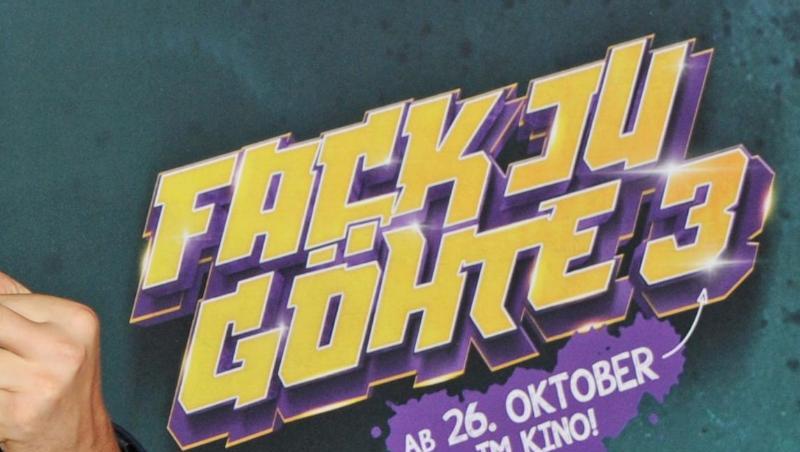 Ein Mann zeigt zur Filmpremiere des Films "Fack ju Göhte 3" vor dem Schriftzug des Filmtitels den Mittelfinger. Foto: Ursula Düren/dpa/Archivbild