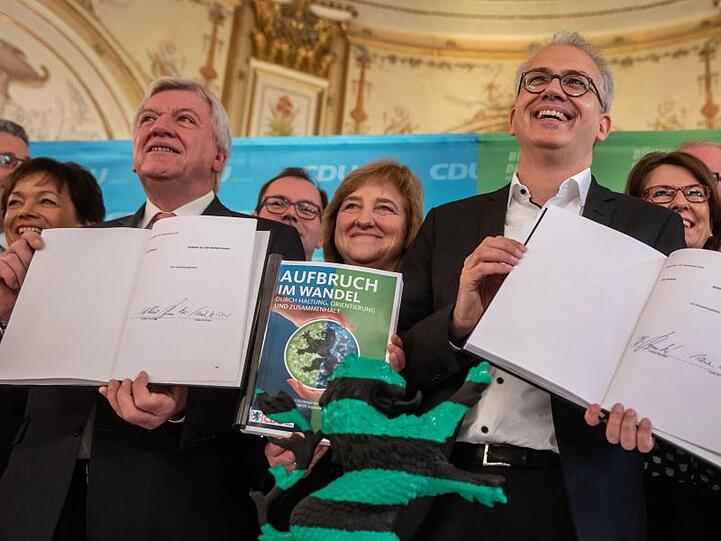 Prima Klima bei Schwarz-Grün: Der hessische Ministerpräsident Volker Bouffier (l, CDU) und Wirtschaftsminister Tarek Al-Wazir (Grüne) mit dem unterzeichneten Koalitionsvertrag.