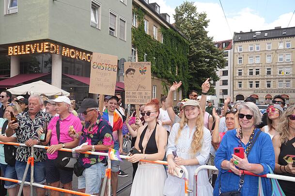 Tausende von Münchnern stehen am Straßenrand und sehen der CSD-Parade zu. Tausende von Münchnern stehen am Straßenrand und sehen der CSD-Parade zu.