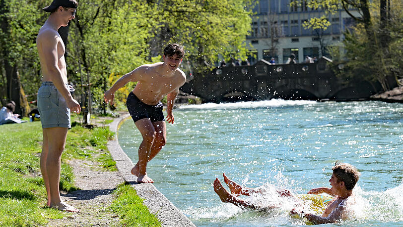 Peter, Maximilian und Julian (von links) springen in den Eisbach im Englischen Garten. Nach einer k&uuml;hlen Phase bringt der Fr&uuml;hling milde Temperaturen und viel Sonne.