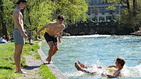 Peter, Maximilian und Julian (von links) springen in den Eisbach im Englischen Garten. Nach einer k&uuml;hlen Phase bringt der Fr&uuml;hling milde Temperaturen und viel Sonne.