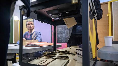 Ein Beamter beobachtet, wie W&auml;hler w&auml;hrend der ersten Runde der franz&ouml;sischen Kommunalwahlen 2026 in Perpignan, S&uuml;dfrankreich, ihre Stimme abgeben.