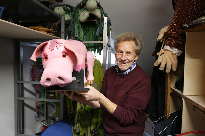 Siegfried Böhmke, Intendant vom Marionettentheater, mit einem Schweinchen, das noch Fäden benötigt.