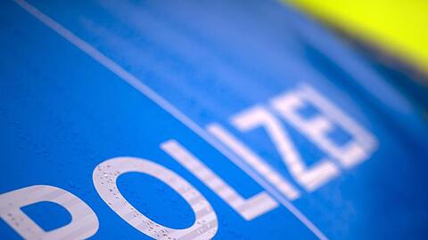 Der Schriftzug "Polizei" steht auf einem Streifenwagen.