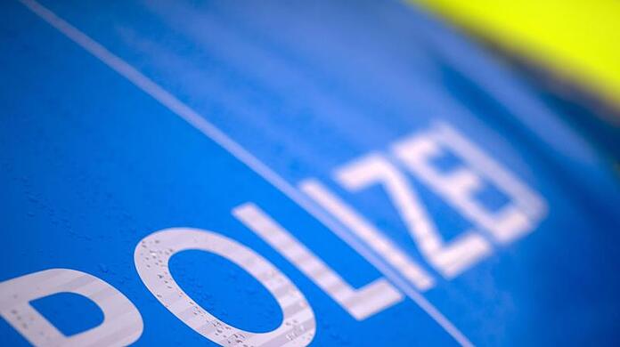 Der Schriftzug "Polizei" steht auf einem Streifenwagen.