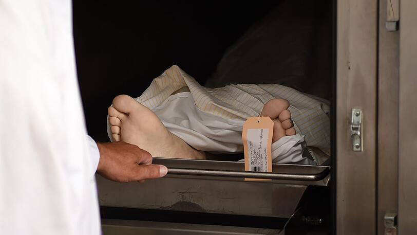 Ein Rechtsmediziner verschliesst in der Pathologie eine Kühlkammer in der eine Leiche liegt. (Symbolbild)
